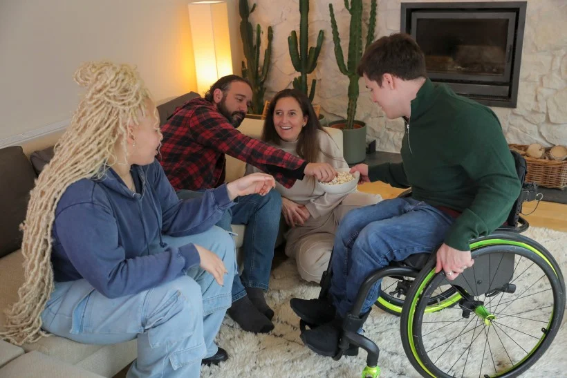 Group of diverse friends sharing popcorn in living room at home