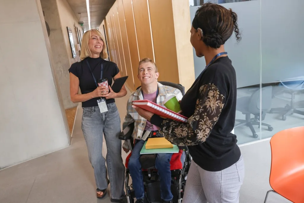 Support worker smiling with two NDIS participants
